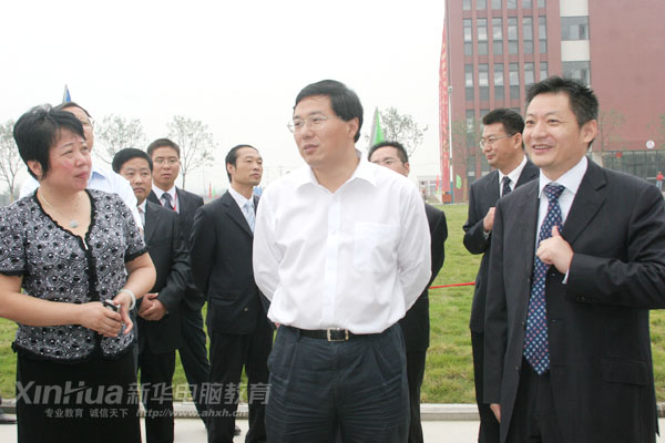新华电脑教育负责人(右)向吴市长(中)介绍新校区建设情况