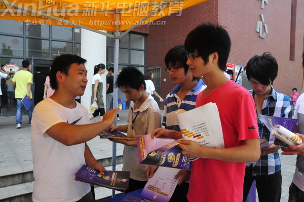 现场报名工作人员正在向前来报名咨询的新华学子介绍报名要求