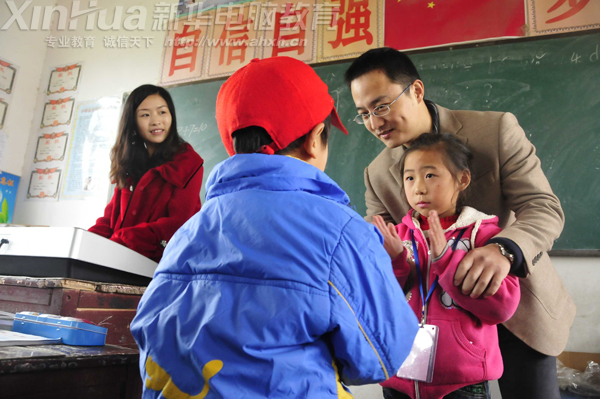 两个孩子在支教老师的鼓励下大胆走上讲台示范着儿歌《你的名字