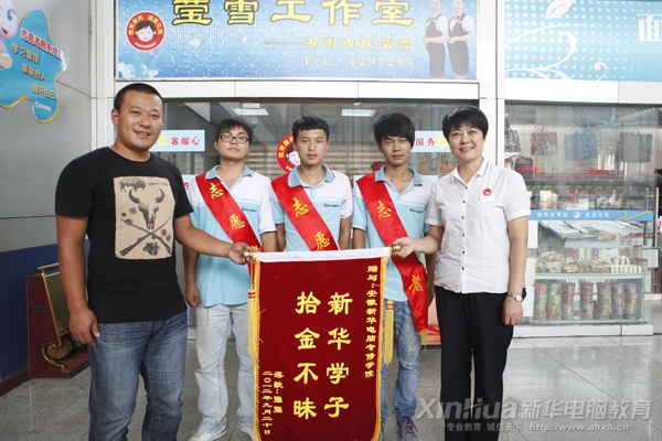 新华学子拾金不昧。图为:失主委托车站工作人员授予新华学子锦旗
