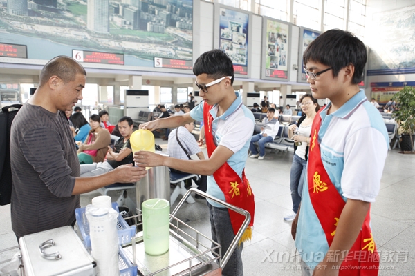 新华车站志愿服务队的学子正在为旅客递送热水